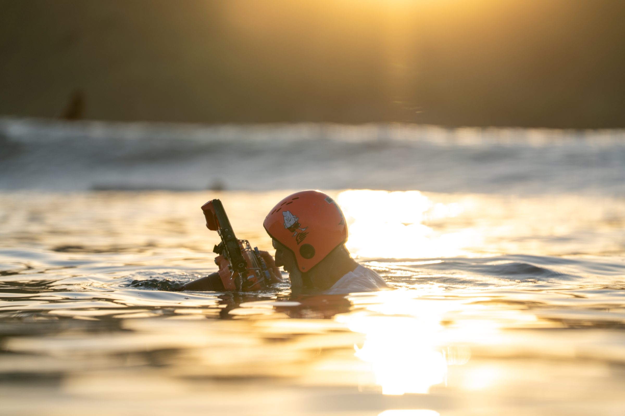Tommy Pierucki shooting surf from the water at golden hour with his water housing.